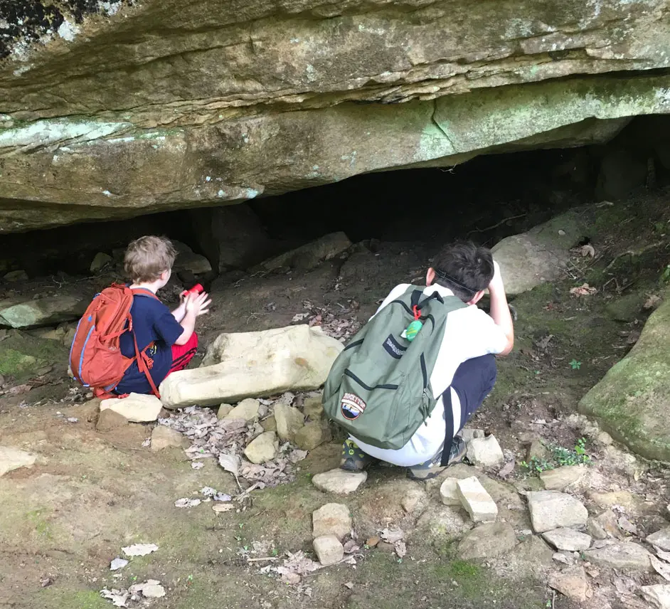 Two childrens are looking in the cave