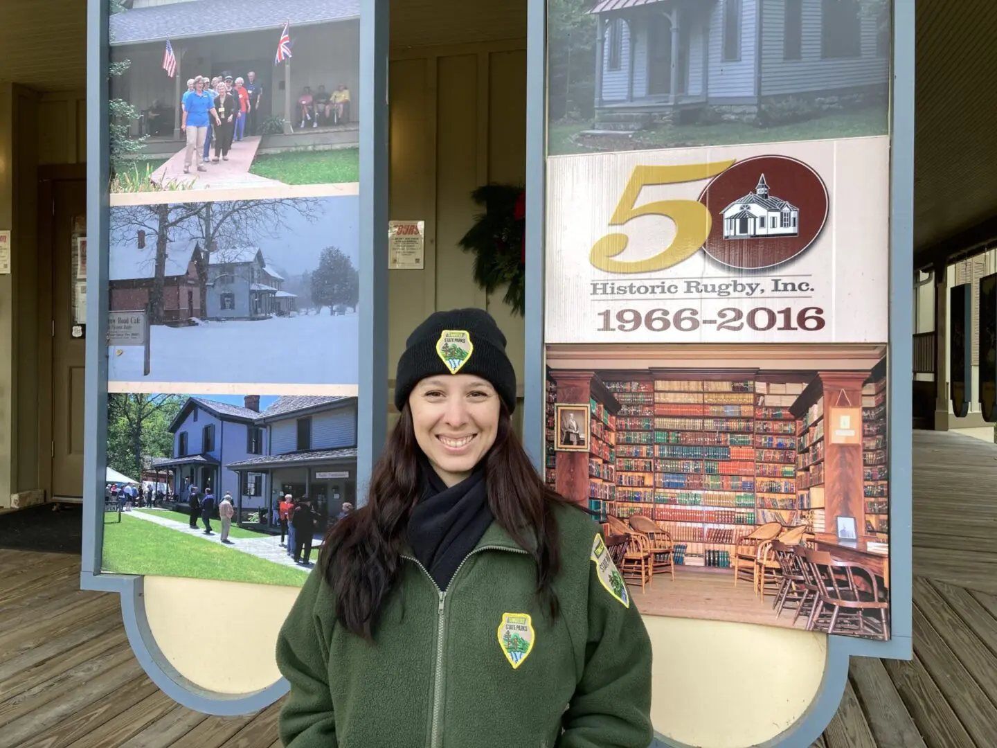 a woman in front of Historic Rugby signage