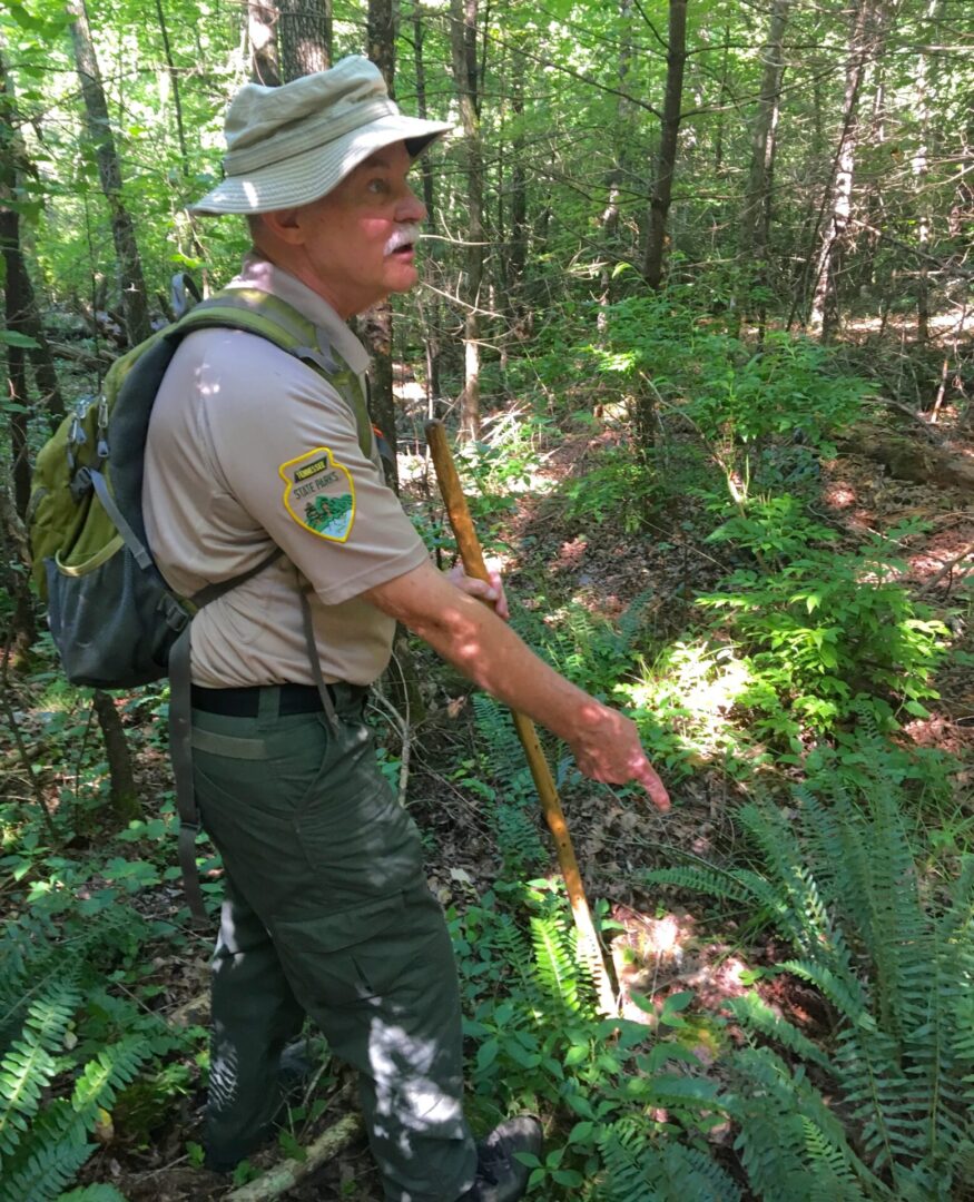 Randy Hedgepath pointing a ranger in the forest