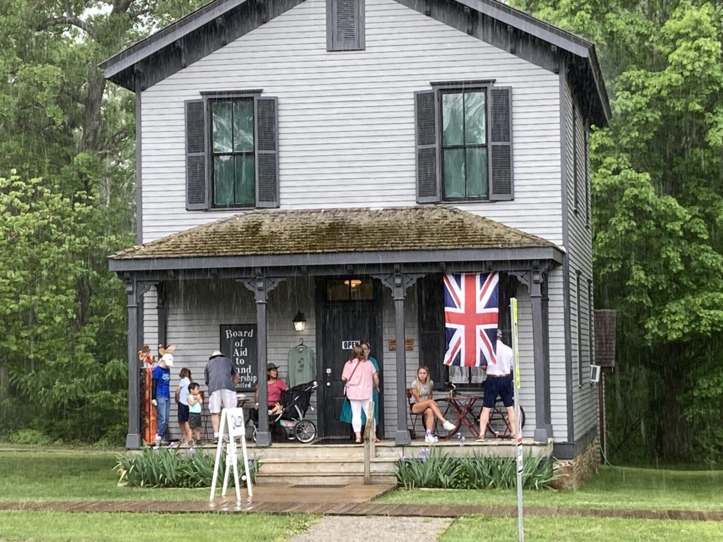 People standing outside a house due to rain