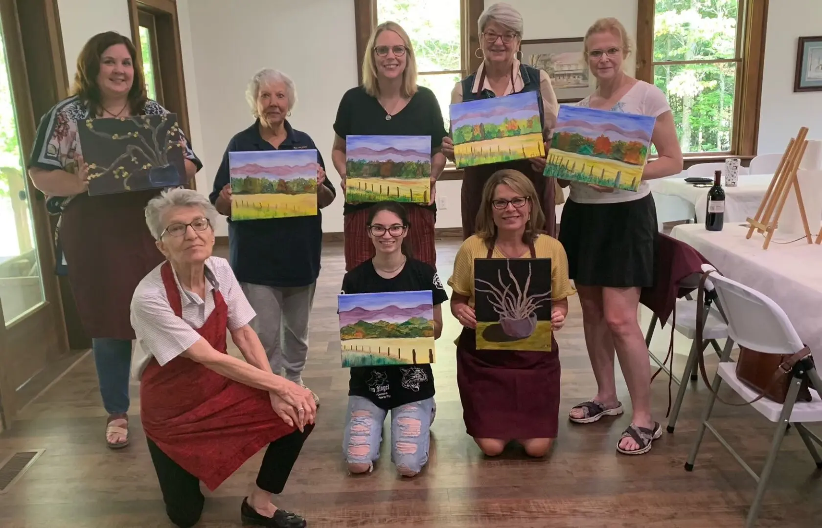 Women posing with their paintings